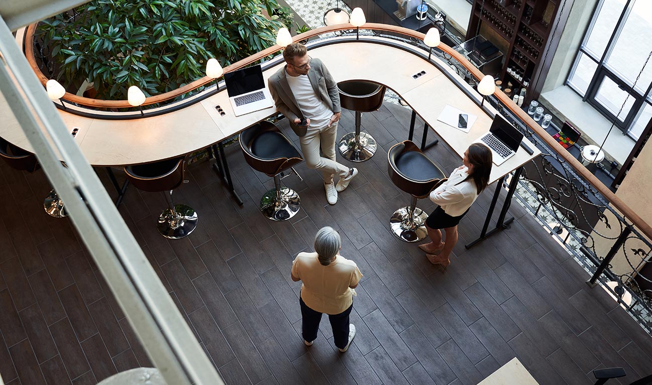 An overhead shot of 3 people talking in a modern office